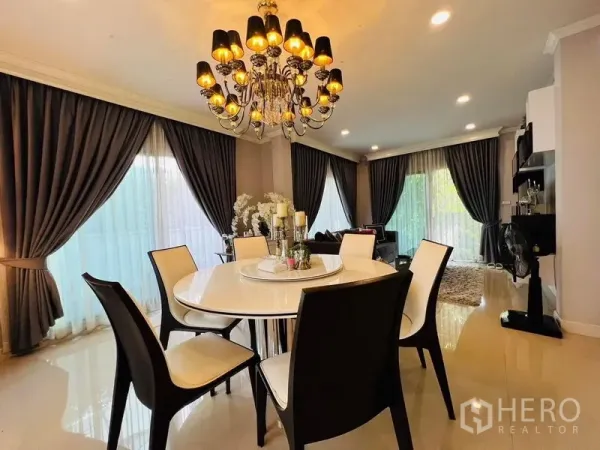 บ้าน ให้เช่าหรือขายในBang Khen, Bangkok - โต๊ะทานอาหารทรงกลมใต้โคมระย้าหรู ผ้าม่านสูงจรดเพดาน แสงไฟอบอุ่น