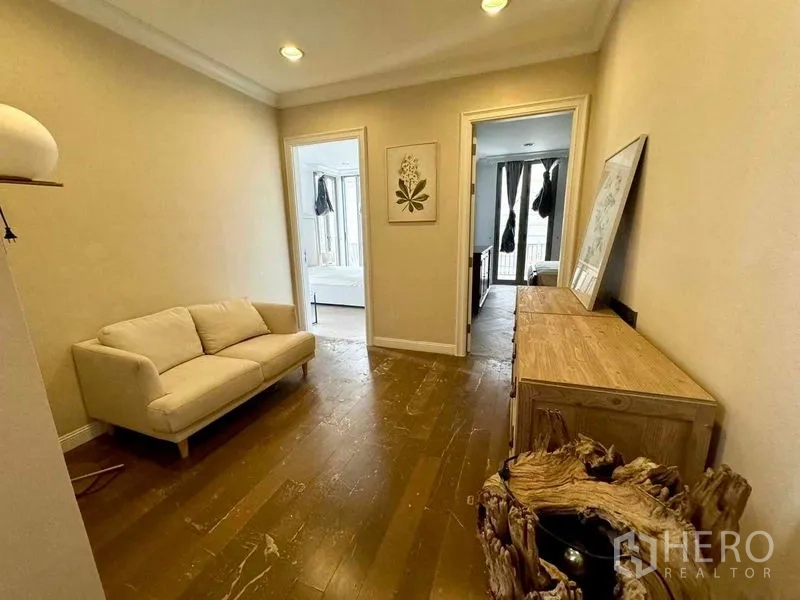 Townhouse for rent in Watthana, Bangkok - Upper-floor foyer with small sofa and wood console leading to bedrooms.