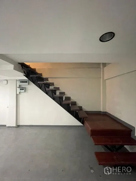 Home Office for rent in Chatuchak, Bangkok - Industrial-style metal staircase with wooden treads along a white wall.