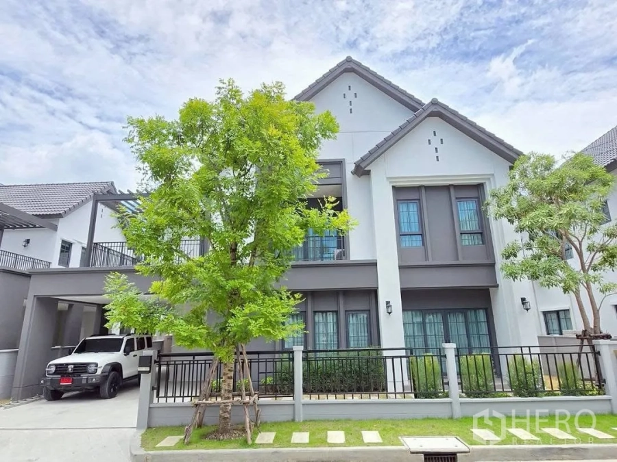 Detached House for rent in Bang Phli, Samut Prakan - Contemporary two-storey house exterior with gated driveway, carport, and mature trees.