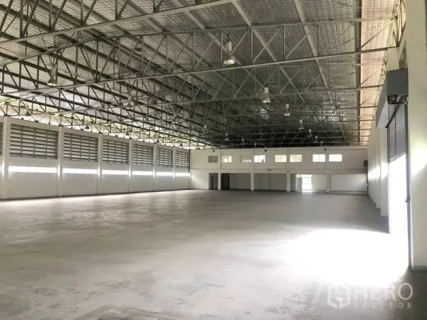 Factory for rent or sale in Bang Pa-in, Phra Nakhon Si Ayutthaya - Open warehouse space with roller shutter doors, skylights and ventilated side walls.