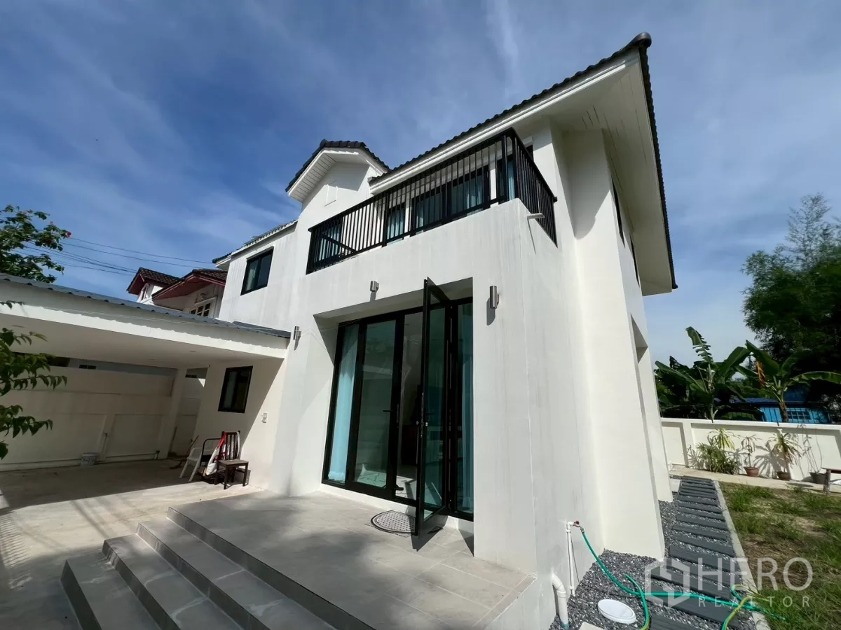 Detached House for rent in Suan Luang, Bangkok - Front terrace and balcony view of the freshly painted façade and covered parking.