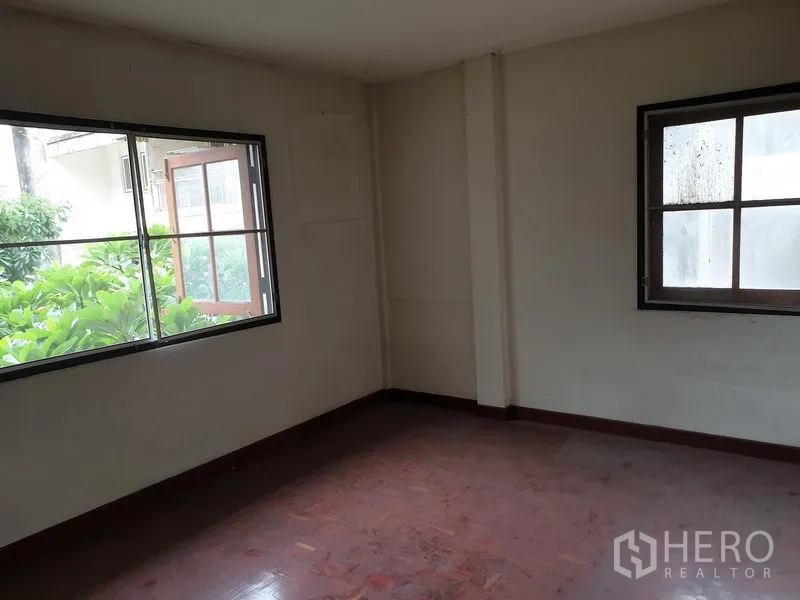 Detached House for rent or sale in Watthana, Bangkok - Corner bedroom with large windows overlooking greenery and ample natural light.