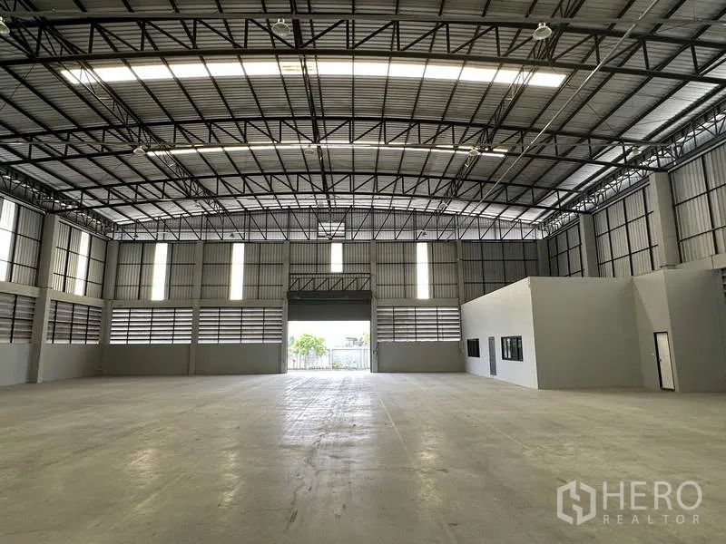 Warehouse for rent in Bang Phli, Samut Prakan - Front loading bay with wide shutter opening for forklifts and a separate office entrance.