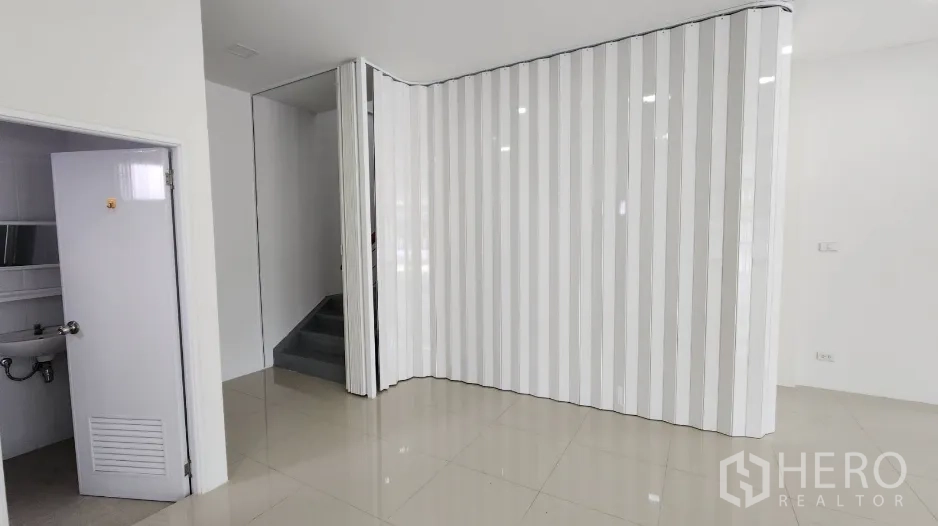 Factory for rent in Bang Bo, Samut Prakan - Restroom door, folding partition and stairwell inside the office zone.