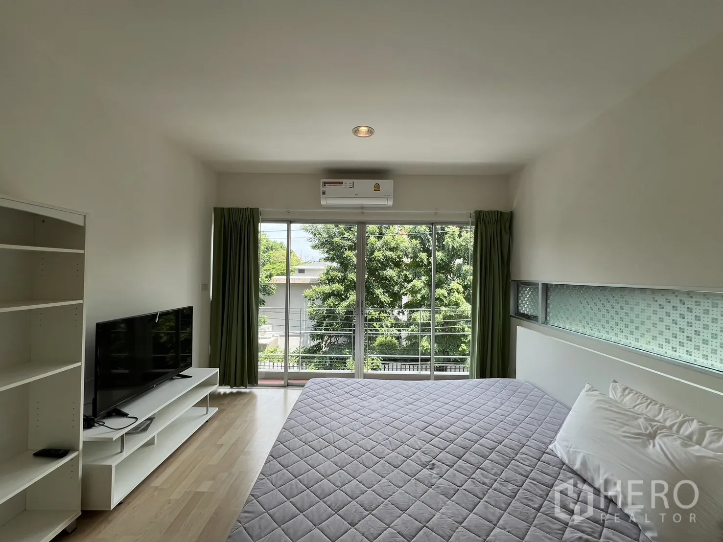 Townhouse for rent in Suan Luang, Bangkok - Bedroom corner with wardrobe, bed, and side window.
