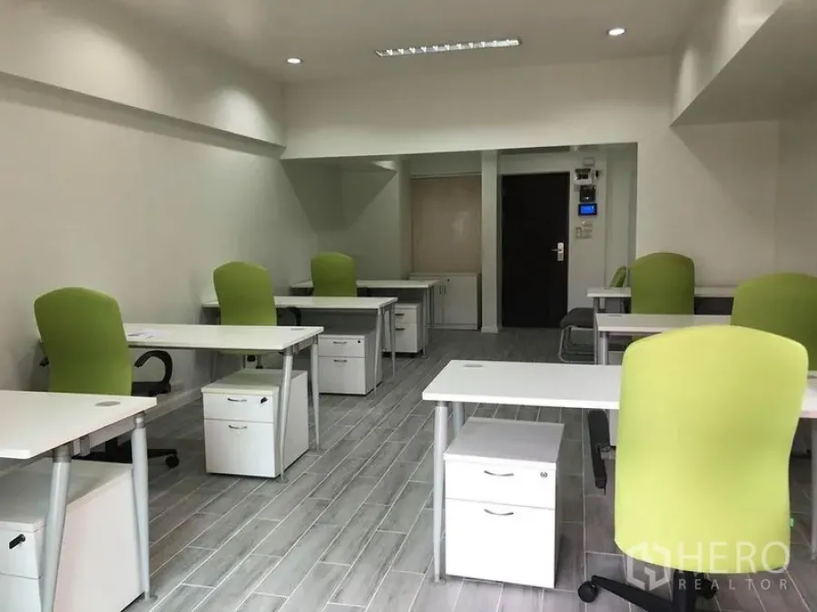 办公空间 出租在Khlong Toei, Bangkok - 明亮的配家具办公室，多张书桌、绿色办公椅、嵌入式照明与储物柜。