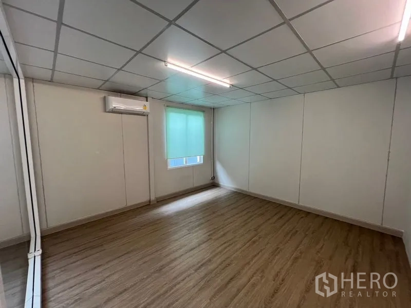 Warehouse for rent in Prawet, Bangkok - Air-conditioned office space with window blind and wood-look flooring.