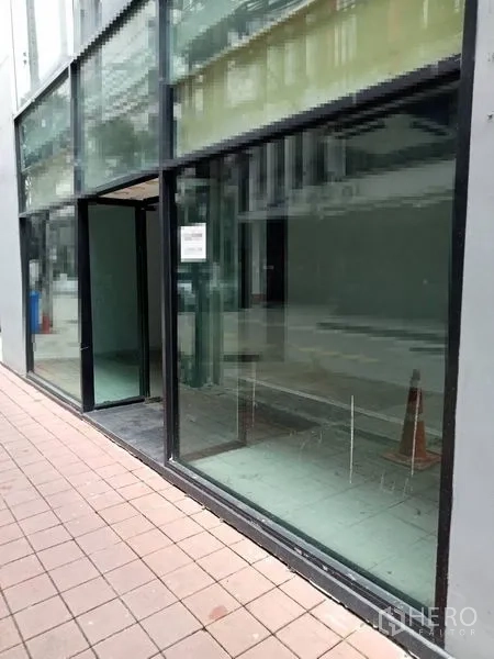 零售空间 出租在Watthana, Bangkok - 沿人行道的玻璃店面与入口外观。