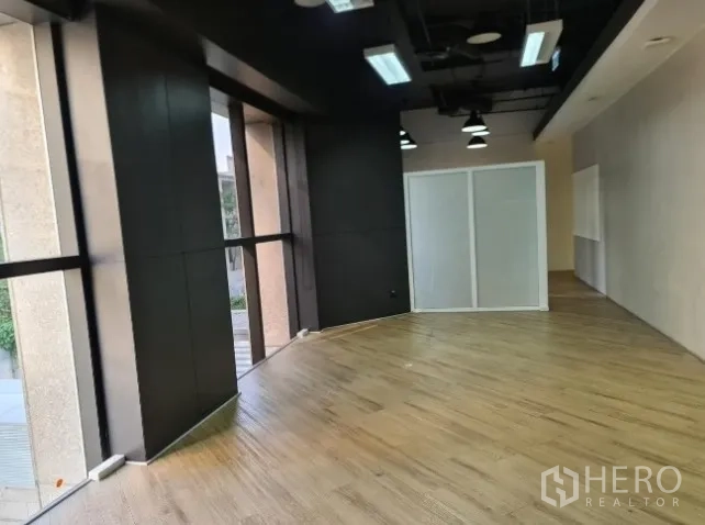 Office Space for rent - Open-plan office zone with large windows and curved wood flooring.