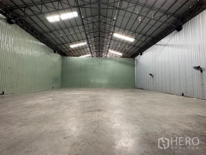 货栈 出租在Pak Kret, Nonthaburi - 开放式仓库，挑高天花、金属包墙与明亮顶灯。