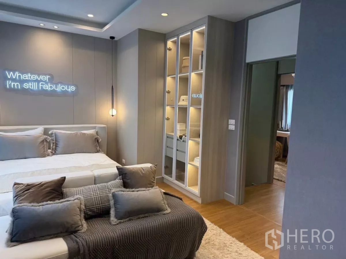 Townhouse for rent in Bang Phli, Samut Prakan - Stylish master bedroom with king bed, pendant light and illuminated wardrobe display.