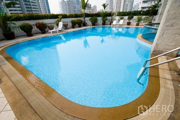 Apartment for rent in Khlong Toei, Bangkok - Rooftop swimming pool with sun loungers and city skyline views in a Khlong Toei apartment.
