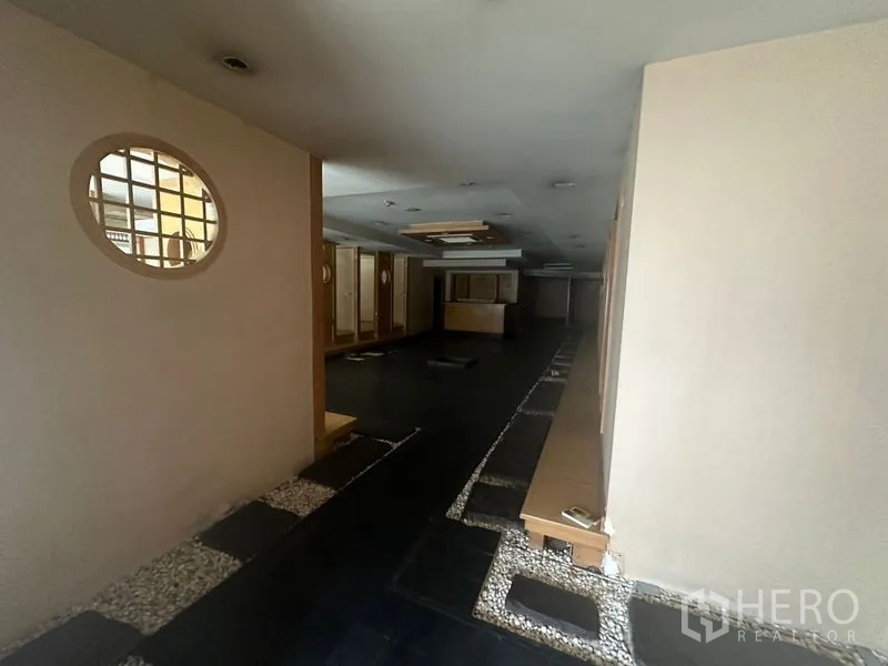 Retail Space for rent in Bang Rak, Bangkok - Open-plan area with dark stone floor, pebble borders, and wooden partitions.