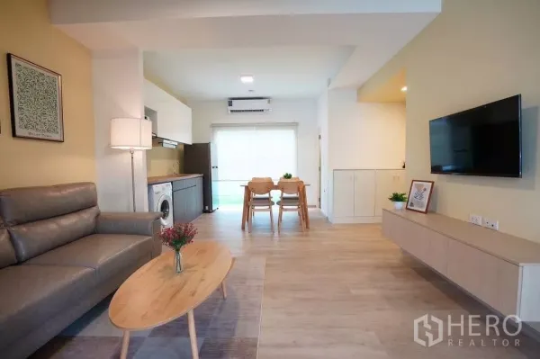 Townhouse for rent in Bang Phli, Samut Prakan - Living and dining area with wall-mounted TV, built-in cabinet and wide window