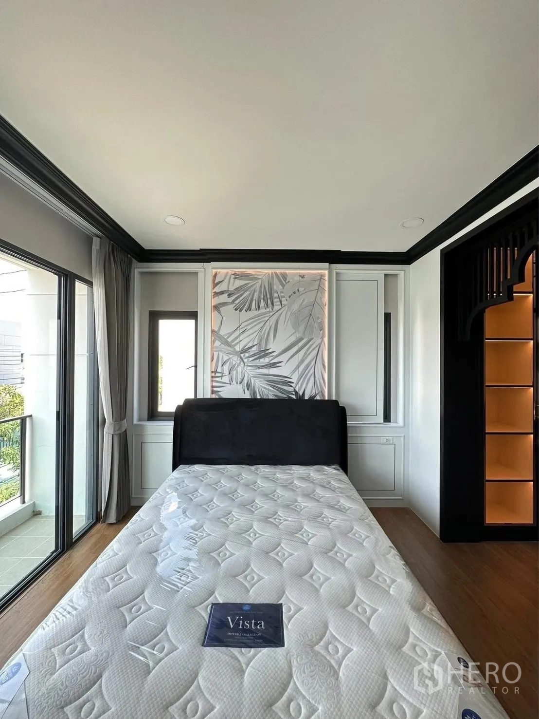 Detached House for rent in Bang Phli, Samut Prakan - Bedroom with large windows, balcony access, and upholstered bed against a decorative panel.