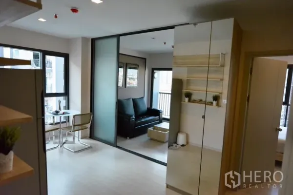 Condominium for sale in Khlong Toei, Bangkok - Open-plan dining and living areas separated by a frosted sliding partition with access to a balcony.