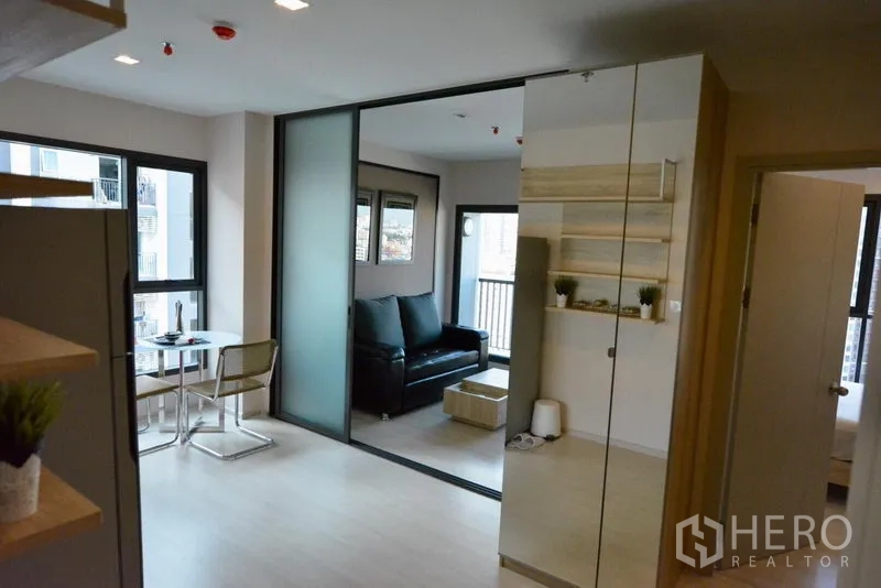 Condominium for sale in Khlong Toei, Bangkok - Open-plan dining and living areas separated by a frosted sliding partition with access to a balcony.