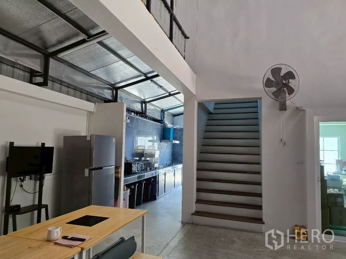 Warehouse for rent or sale in Khlong Toei, Bangkok - Pantry and staircase area inside the warehouse with a wall-mounted fan.