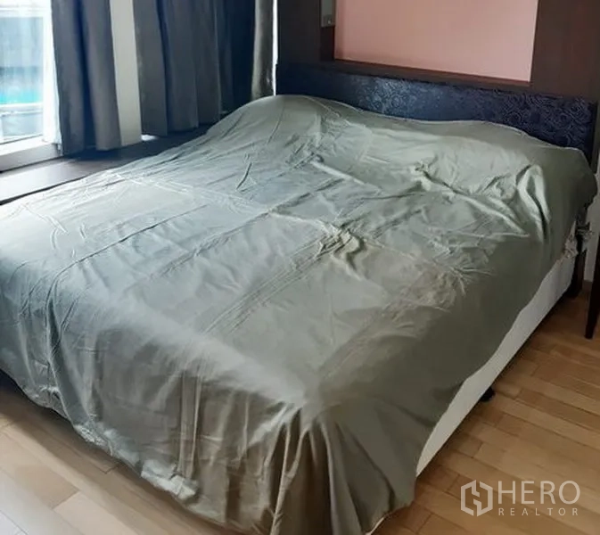 Condominium for rent in Khlong Toei, Bangkok - Master bedroom with large bed, headboard and wide windows for natural light.
