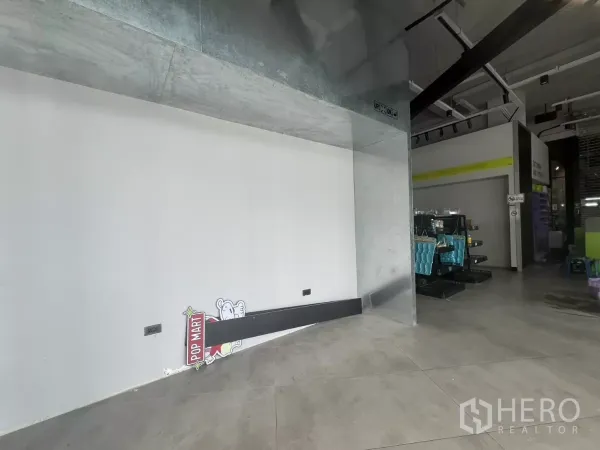 Retail Space for rent - Display niche with metal cladding and a clean white wall beside the open sales area and industrial-style ceiling.