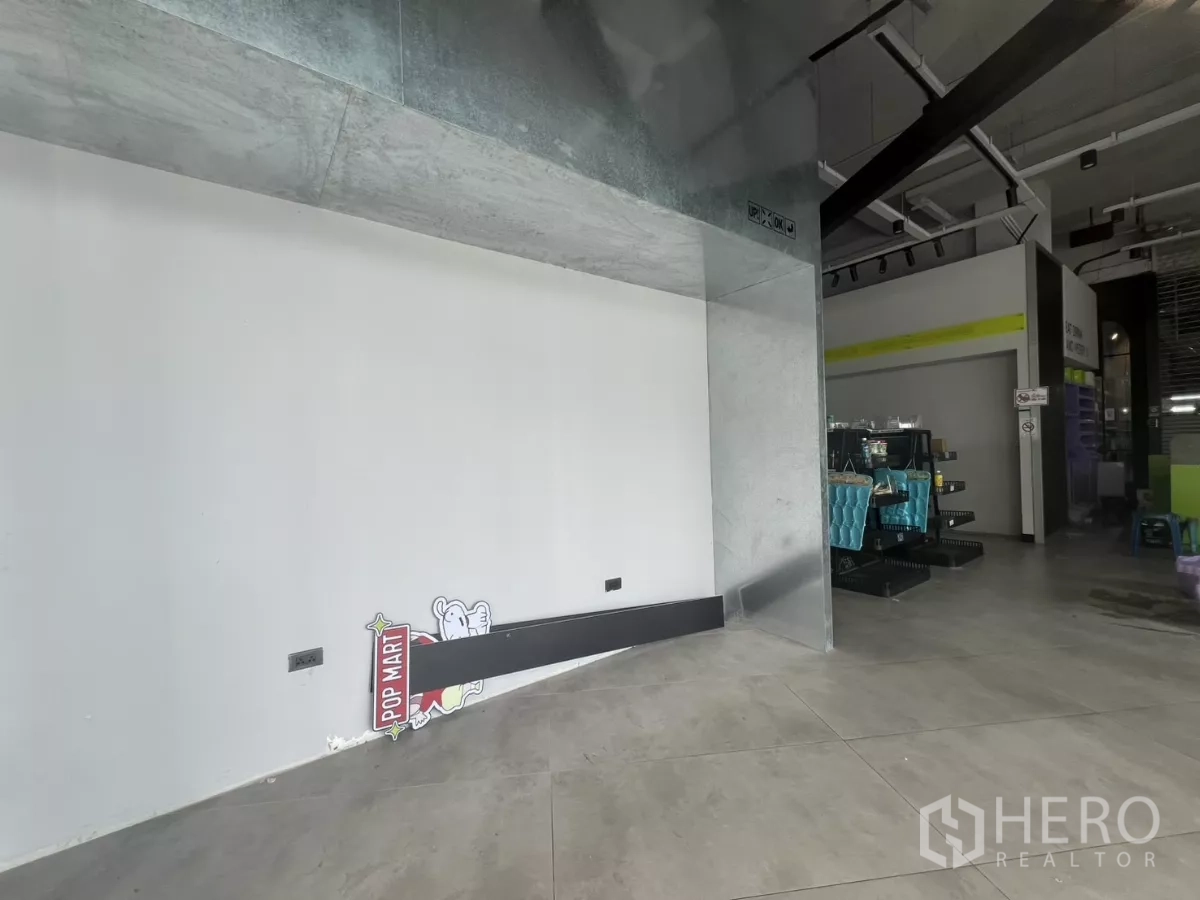 Retail Space for rent - Display niche with metal cladding and a clean white wall beside the open sales area and industrial-style ceiling.