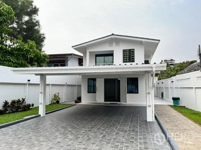 Detached House for rent in Phaya Thai, Bangkok - White two-storey detached house with covered carport and long driveway.