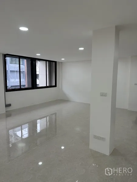 Office Space for rent or sale in Huai Khwang, Bangkok - Corner office room with large window and shiny tile floor.