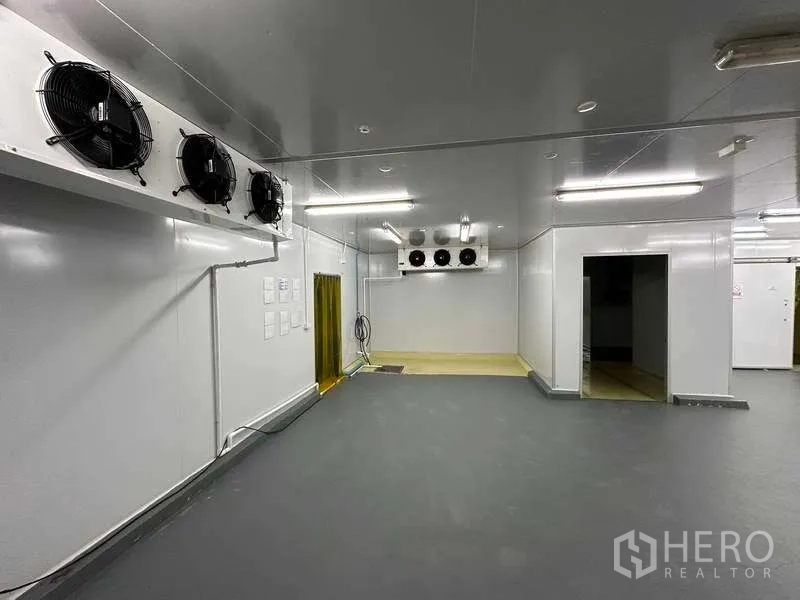 Warehouse for rent in Khlong Luang, Pathum Thani - Insulated room interior with wall-mounted condenser fans and PVC strip doors.
