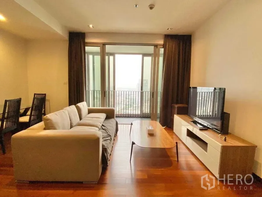 Condominium for rent - Living and dining area facing a glass-door balcony, hardwood floors and city outlook.
