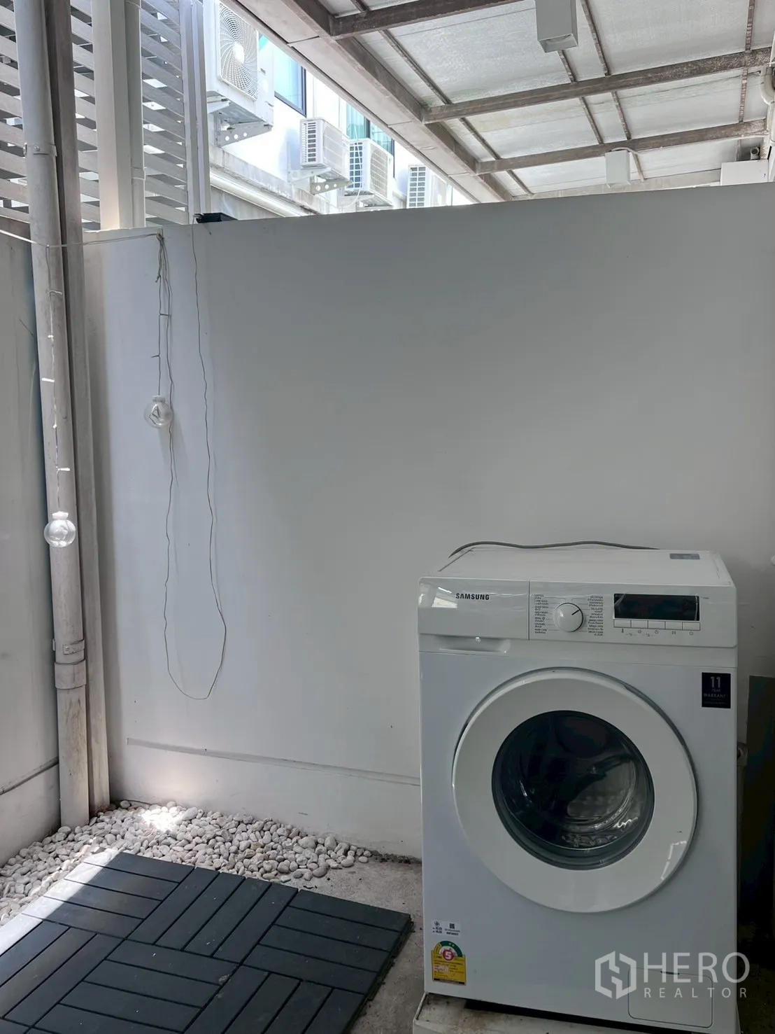Townhouse for rent in Bang Phli, Samut Prakan - Covered laundry area at the rear with front-load washing machine.
