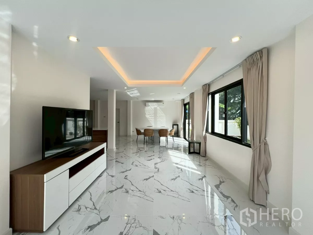 Detached House for rent in Suan Luang, Bangkok - Bright open-plan living and dining area with marble-look floors and recessed lighting.