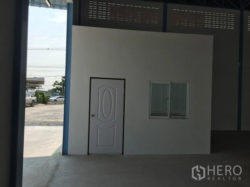 工厂 出租在Pathum Thani - 厂房内的白色办公室盒体，带门与窗，旁有进出车道与采光。