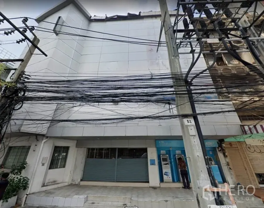 อาคารพาณิชย์ ให้เช่าหรือขายในKhlong Toei, Bangkok - มุมมองด้านหน้าอาคารพาณิชย์หลายชั้น ประตูม้วนเหล็กและสายไฟหนาแน่นในย่านพระโขนง