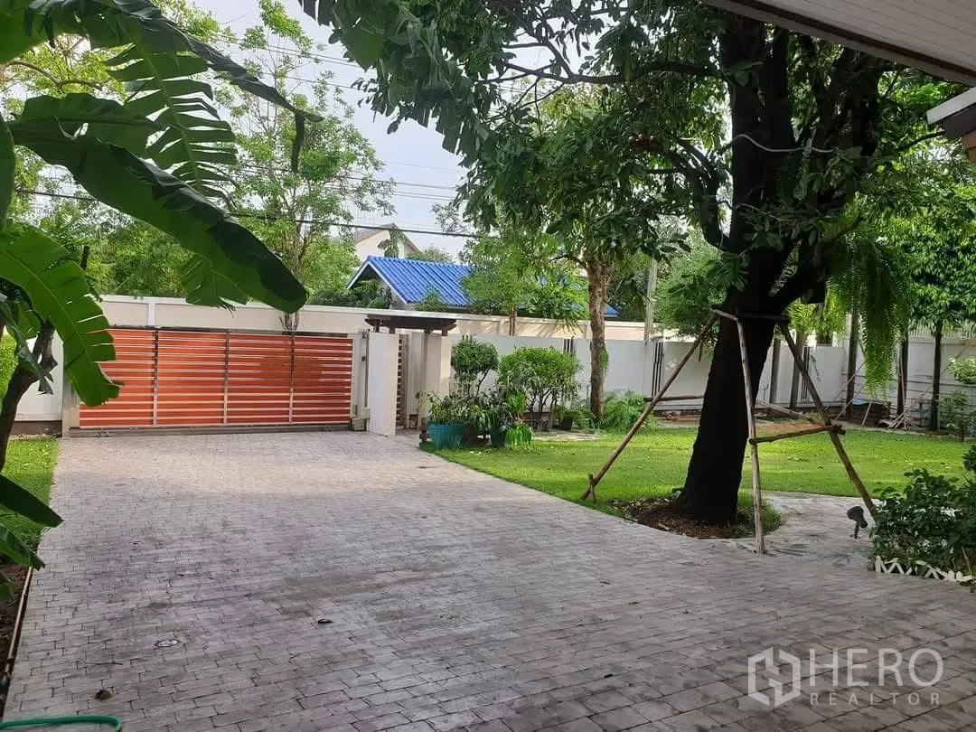 Detached House for rent in Bang Kapi, Bangkok - Wide paved driveway with sliding gate and mature garden.