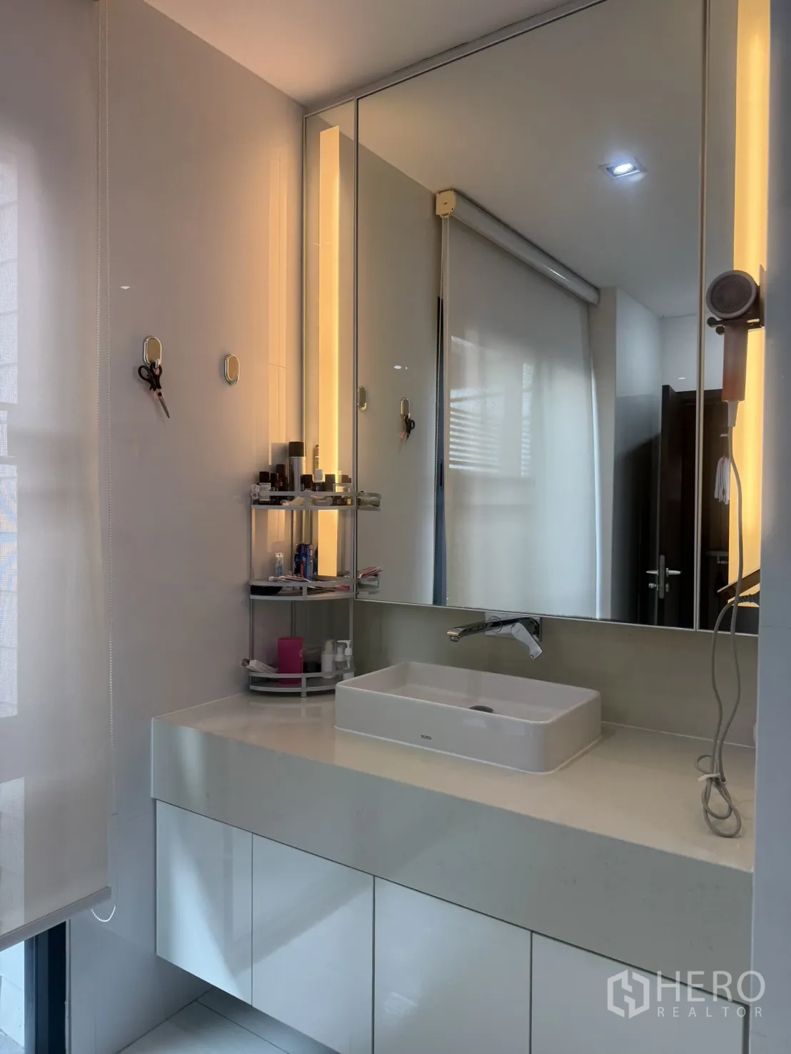 Detached House for rent in Bang Kapi, Bangkok - Modern bathroom vanity with large mirror, ambient lighting, and storage cabinets.