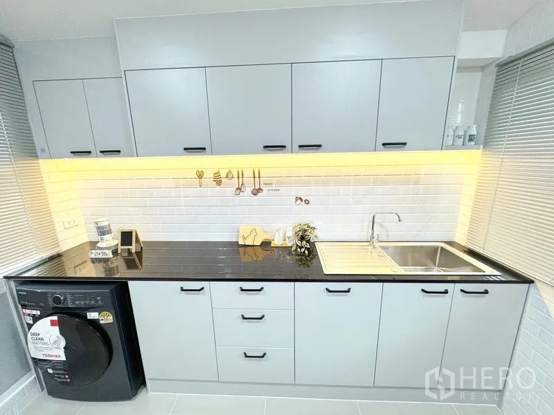 Detached House for rent - Second kitchen counter with sink, storage cabinets and under-cabinet lighting.