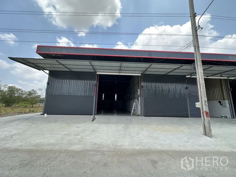 Warehouse for rent in Khlong Sam Wa, Bangkok - Front view of a modern steel warehouse with a wide roller shutter and covered loading bay.