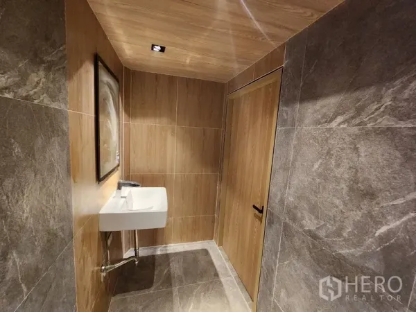 Retail Space for rent in Pathum Wan, Bangkok - Restroom finished with wood accents, stone-look tiles and wall-mounted sink.