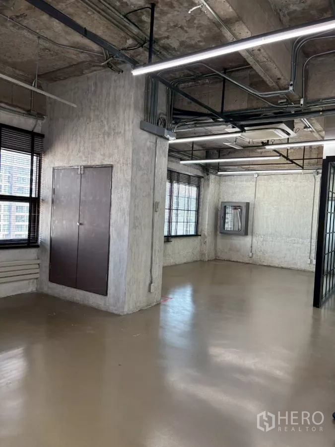 办公空间 出租在Watthana, Bangkok - 狭长的开放式办公室，多扇窗、外露设备与抛光地面。