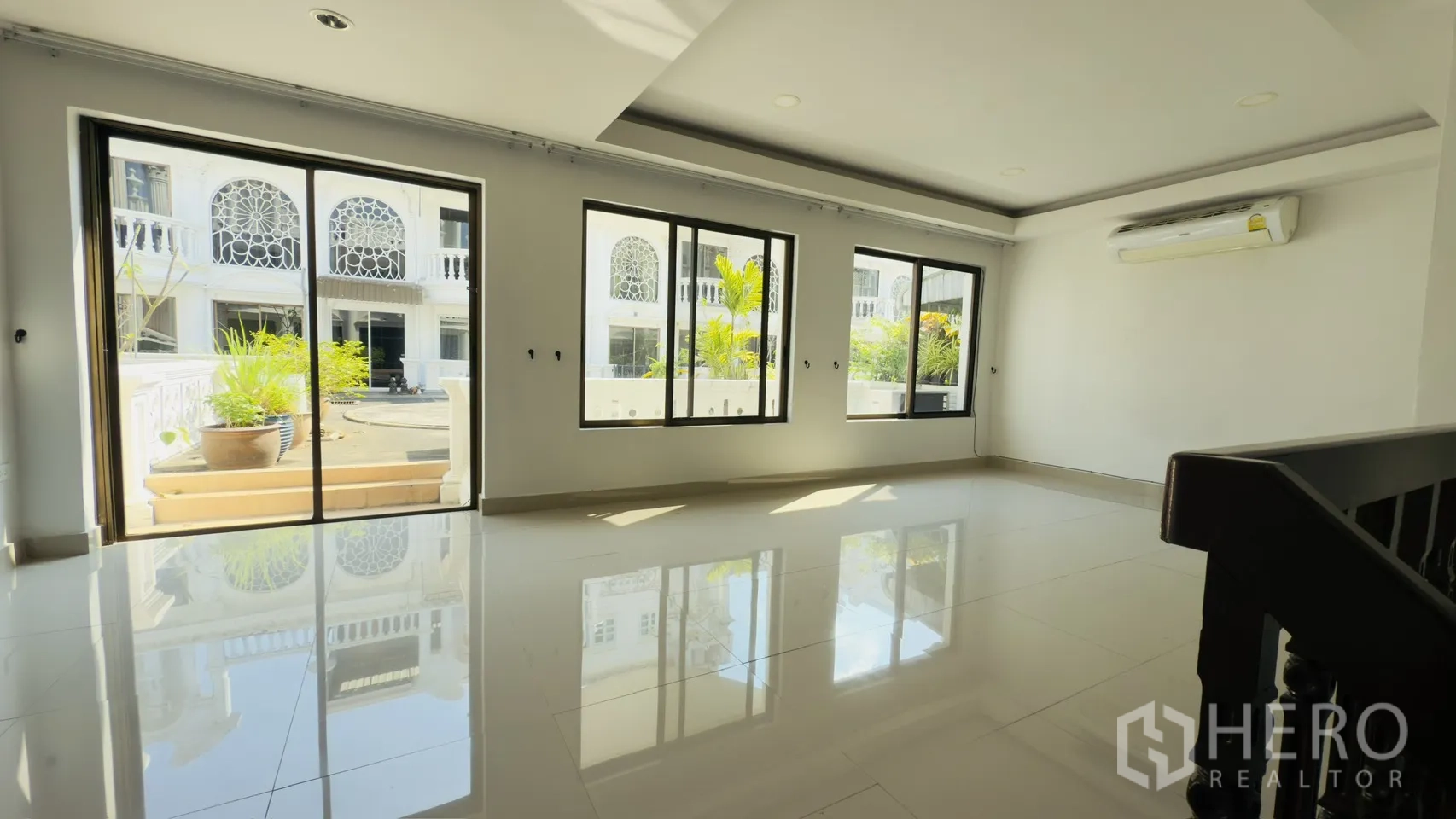 Townhouse for rent in Watthana, Bangkok - Upper living space with sliding doors to a terrace, large windows, and air conditioning.