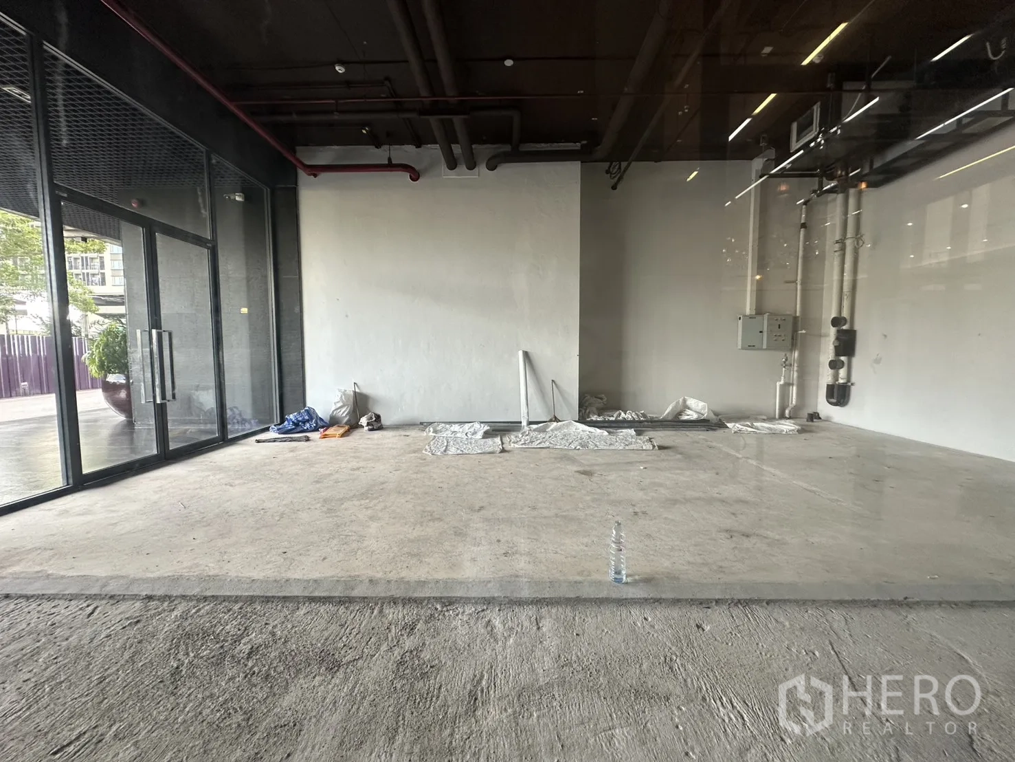 零售空间 for rent in Khlong Toei, Bangkok - 开放式室内，水泥地、白墙与可见管线。