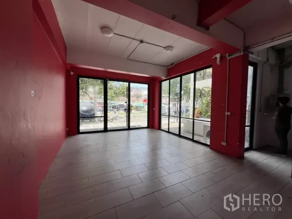 Retail Space for rent in Khlong Toei, Bangkok - Corner showroom space with floor-to-ceiling black-frame windows and a clear street view.