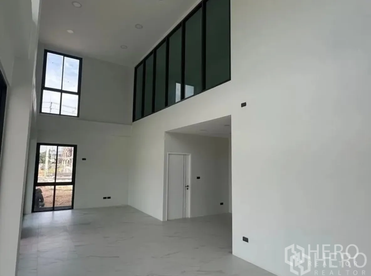 Warehouse for sale in Lam Luk Ka, Pathum Thani - Double-height lobby with white walls, tiled floor and internal mezzanine windows.