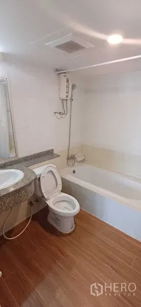 Condominium for sale in Pathum Wan, Bangkok - Clean bathroom featuring a bathtub with shower, toilet and granite-top vanity.