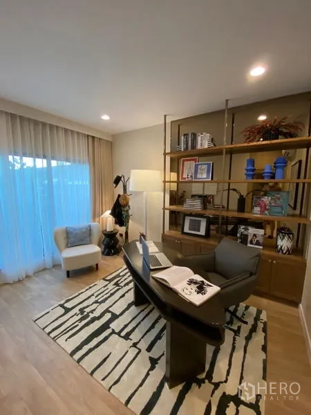 Detached House for sale in Bang Kapi, Bangkok - Cozy home office with built-in shelving, desk and sheer curtains.
