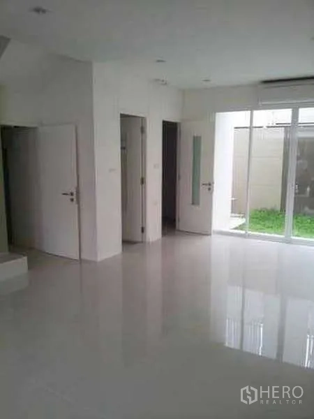 Home Office for rent in Chatuchak, Bangkok - Ground-floor hall with glossy tile floors and sliding glass doors to a small garden.