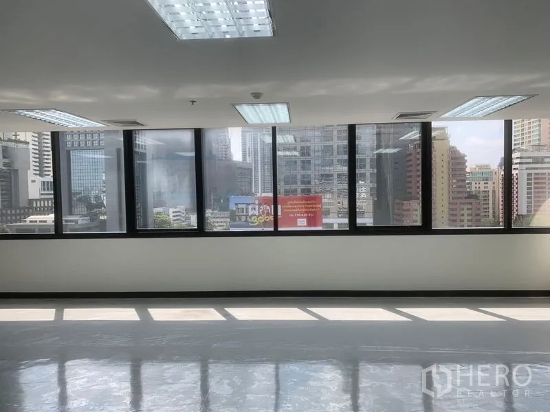 Office Space for rent in Bang Rak, Bangkok - Panoramic Bangkok skyline seen through a long row of office windows.