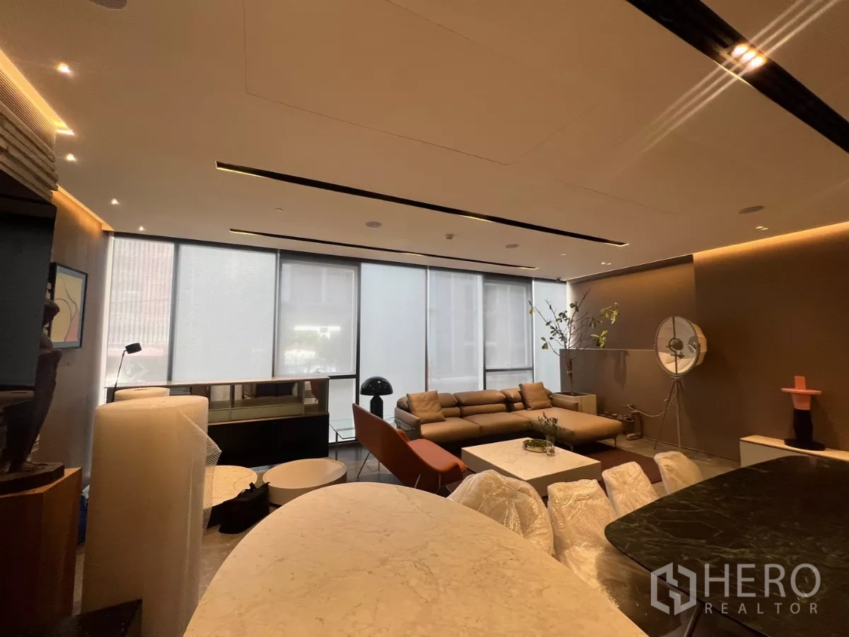 Retail Space for rent - Open-plan retail interior with floor-to-ceiling windows, recessed lighting and sofa seating by a stone-topped counter.