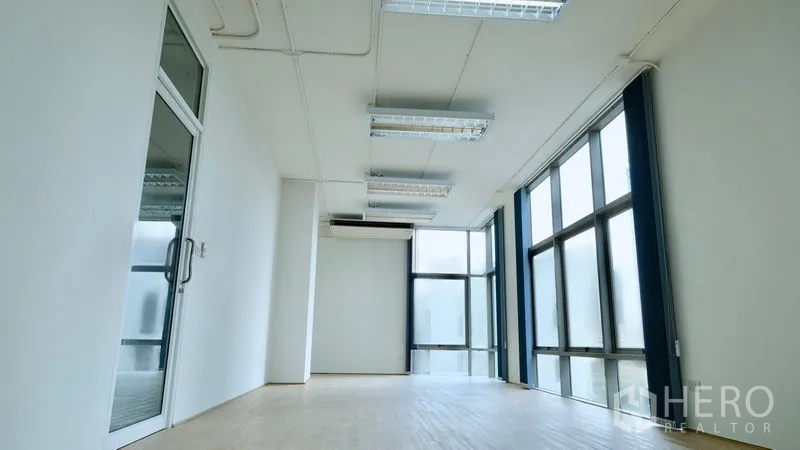 Office Space for rent in Bang Rak, Bangkok - Open-plan office with glass entry door, split-type air conditioner and floor-to-ceiling windows.